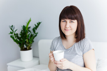good morning concept - happy woman drinking coffee at home