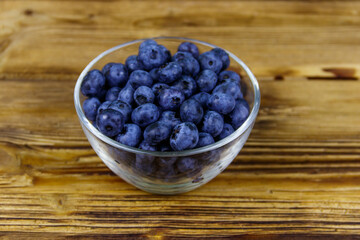 Fresh blueberry in glass bowl on a wooden table