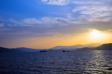 cargo ship travels at sunset
