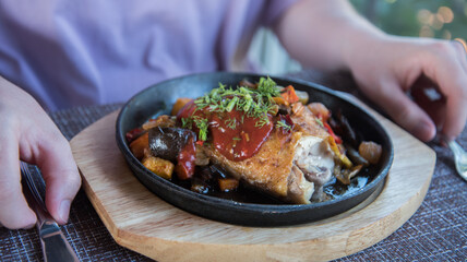 Fried chicken with vegetables. The lunch process. The knife cuts the dish.