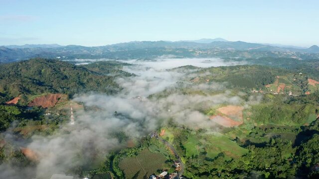 Backward flight above the clouds in the Constanza valley, Dominican Republic, clear day, colorful mountains