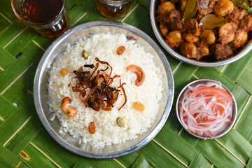 Ghee rice, Neychoru, Pulao made of Basmati rice on green palm mat background Kerala, Tamil Nadu South India. Indian festival 	food for Ramadan, Eid, Iftar party.