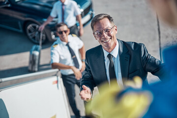 Smiling elegant mature man boarding on plane