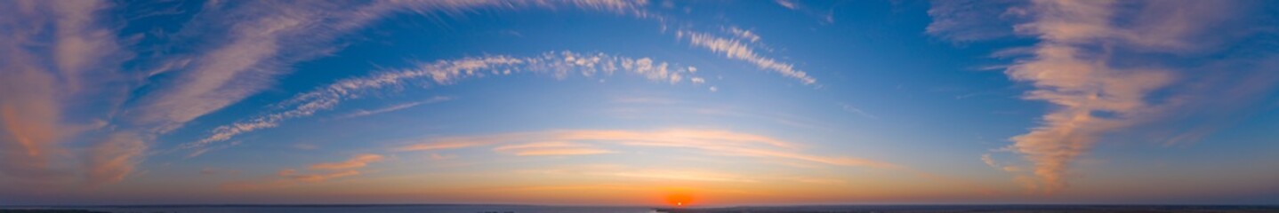 Colorful sky with cirrus clouds during dawn. High resolution panorama. View from drone