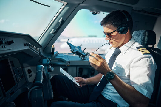 Handsome pilot preparing for departuring from airport