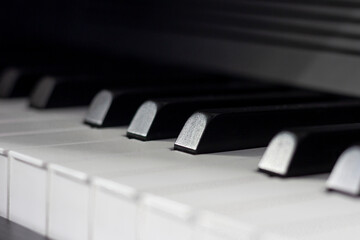Fototapeta na wymiar Black and white piano keys in dim lighting and shadows.