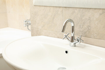 Sink in modern comfortable bathroom in light beige color