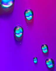 Blue drops of water on a pink background.