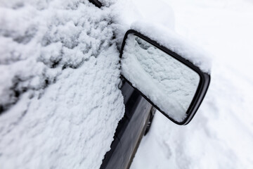 White snow on the mirror of a car