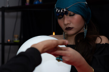 The fortune teller is checking the lines on the customer's hand to make predictions for the future.