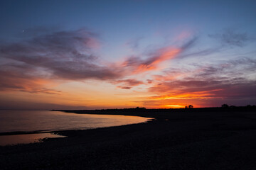 Colorful sunset on a beach with water and sky on background. Summer landscape background. Beautiful natural landscape. Beautiful sunset.