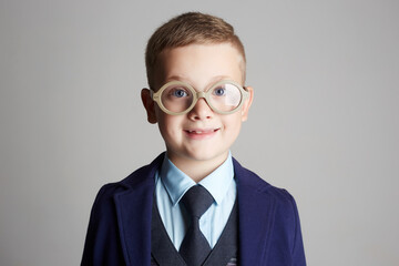 smiling boy with glasses and tie