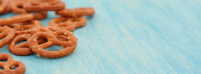 Pretzels on blue wooden table closed up. Popular german cracker snack with salt.
