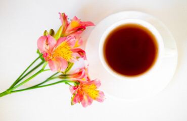 cup of tea with flowers.  alstroemeria and a cup of tea.  morning breakfast. beautiful still life.  flatlay in light colors