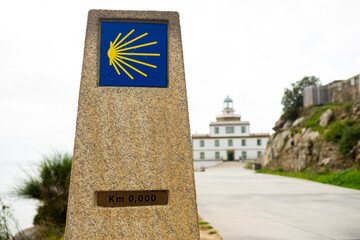 Cape Finisterre milestone, indicating the end of the Camino de Santiago with yellow seashell....