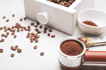 Portafilter with coffee powder and beans on white background