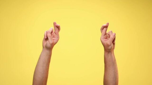 two arms crossing fingers, rotating and dancing on yellow background