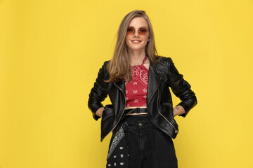 Positive fashion model smiling, holding hands in hips, wearing sunglasses