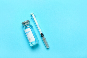 Bottle of insulin with syringe on color background. Diabetes concept