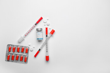 Bottle of insulin with syringes and pills on white background. Diabetes concept