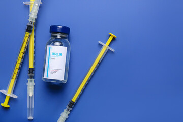 Bottle of insulin with syringes on color background. Diabetes concept