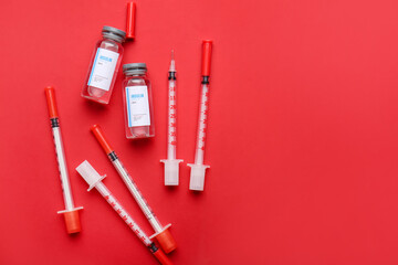 Bottles of insulin with syringes on color background. Diabetes concept