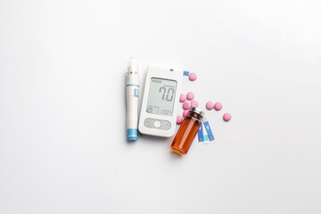 Glucometer, lancet pen, pills and bottle of insulin on white background. Diabetes concept