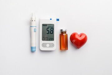 Glucometer, lancet pen, heart and bottle of insulin on white background. Diabetes concept