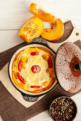 Autumn cooking. Pumpkin casserole on a white wooden background. Vertical photo