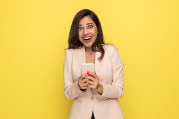surprised young woman in pink suit holding phone