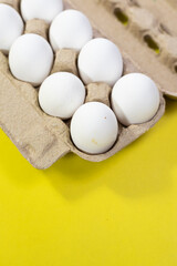 eggs in crate on yellow background top shot