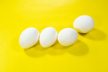 five eggs on vibrant yellow background