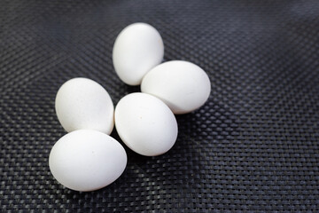  five eggs on textured black background