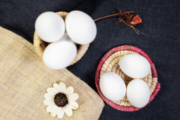 top shot of eggs on black background jute bag and artificial flower