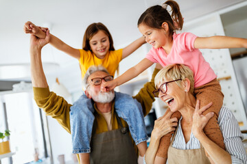 Obraz premium Grandchildren having fun at home while playing with their grandparents