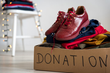 Cardboard donation box full with clothes and shoes. Concept of charity, donation and clothes...