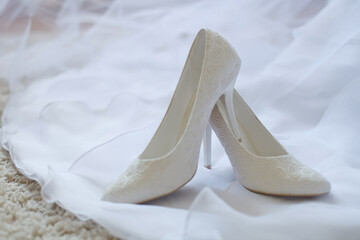 white wedding shoes on veil of bride white dress
