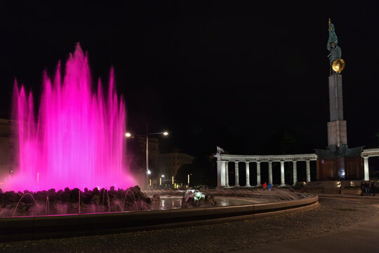 VIENNA, AUSTRIA - SEPTEMBER 26, 2015: pink Hochstrahlbrunnen fountain and War Memorial (Heldendenkmal der Roten Armee, Heroes Monument of Red Army). Memorial with Red Army Soldier was unveiled in1945