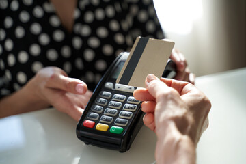 Young woman paying by credit card in the shop