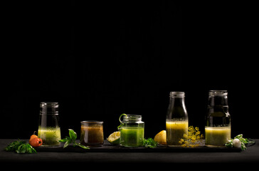 5 homemade salad dressings in glass jars on a dark background.