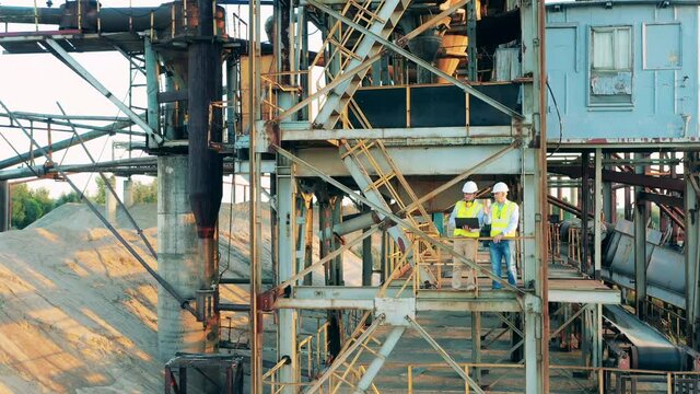 Specialists are standing inside of a metal construction in port