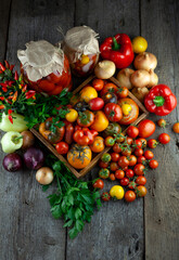 Tomatoes, peppers, onions on the table. Top view. Vegetable food. Still life. Tomato of different varieties. Preservation of the autumn harvest of vegetables. Wooden background. Copy space.