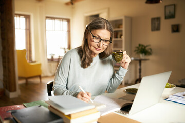 People, aging, retirement and occupation concept. Attractive sixty year old female teacher...