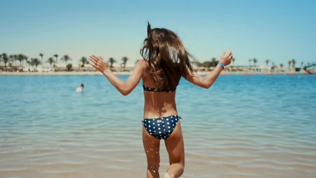 Long hair young woman having fun at beautiful coastline at summer day.