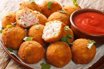 Hot fried sauerkraut balls with ham and cheese close-up in a plate on the table. horizontal