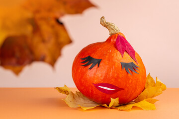 Beautiful halloween happy pumpkin face. Decorated with autumn leaves.