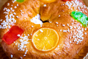 Christmas round fruit cake decorated with fir tree branch, glazed fruits and nuts