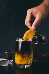 Orange and coffee cocktail on the black background. Shallow depth of field.