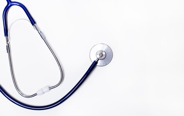A blue stethoscope lies on a white background. Copy space. Medical concept