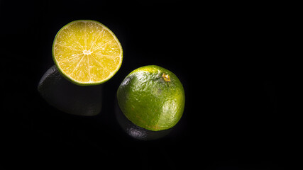 Two halves of fresh lime on a black background close - up